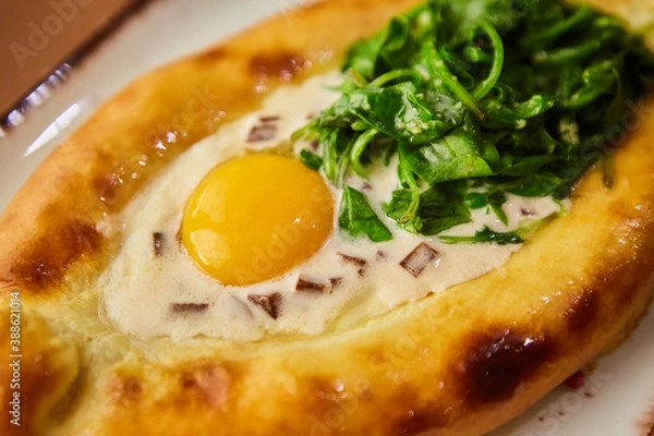 Fototapeta Khachapuri in Adjarian. Open pie with mozzarella and egg. Georgian cuisine.