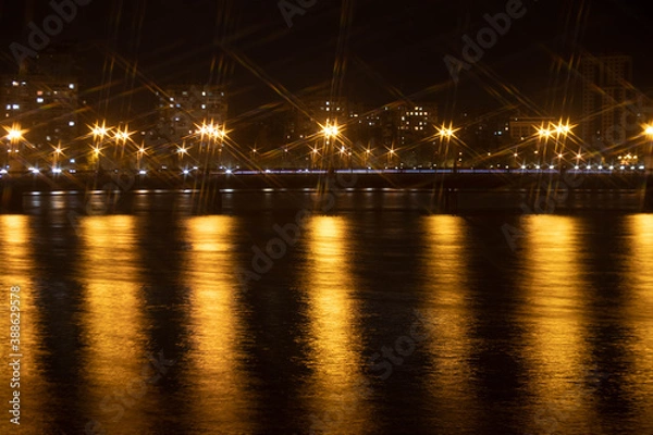 Fototapeta Night city view of the old bridge across the river lanterns six-pointed stars with water reflections