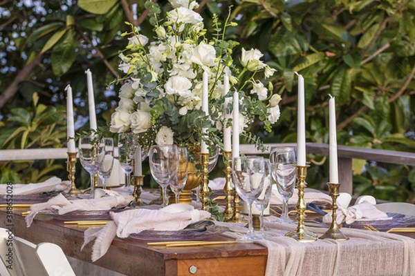 Fototapeta White and Gold Romantic Wedding Table Top Layout Table Spread no people no human tropical location with gold cutlery and scenic view tablescape