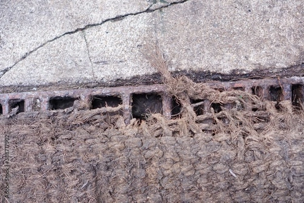 Fototapeta Drain grate channel on footpath concrete.