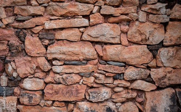Fototapeta Background of red stones forming a wall with space for text