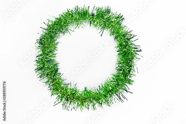 Fototapeta Round circle of bright green tinsel on a white background. Christmas decorations. New year concept