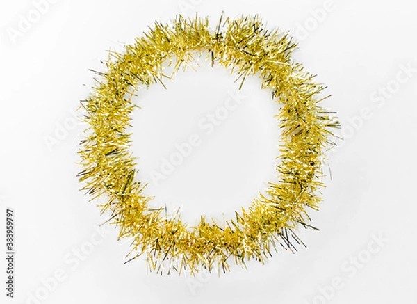 Fototapeta Round circle of yellow, golden tinsel on a white background. Christmas decorations. New year concept