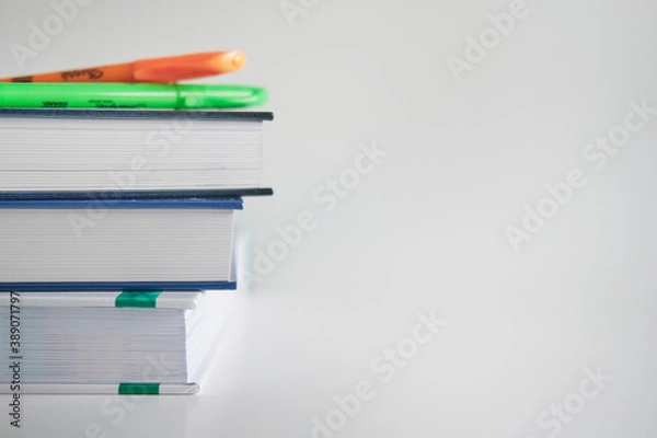Fototapeta Stack of colorful books and pens