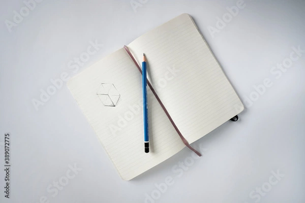 Fototapeta Top view notebook with a sketch and pencil on a white desk