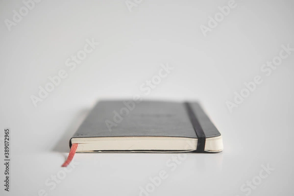Fototapeta Closed notebook on a white desk