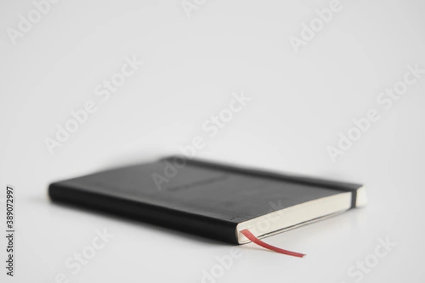Fototapeta Closed notebook on a white desk