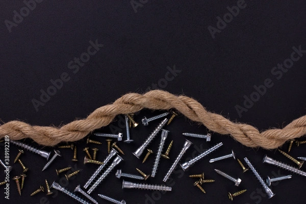 Fototapeta furniture screws, self-tapping screws, rope on a black foil with a place for text