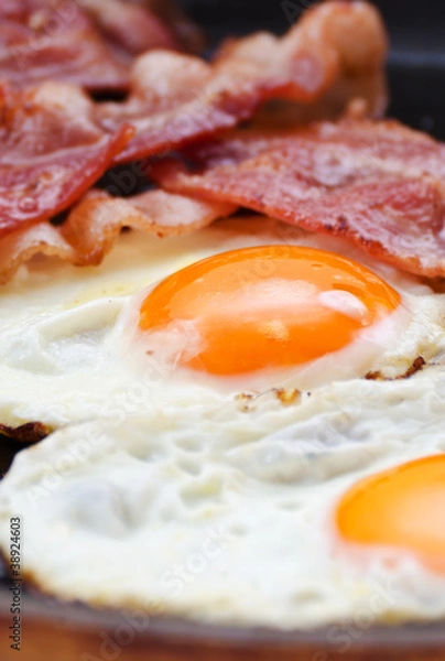 Fototapeta Fried eggs with bacon in a pan