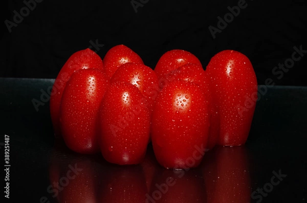 Obraz Close-up on wet cherry tomatoes. Drops of water and bright shiny red. black background with space for text