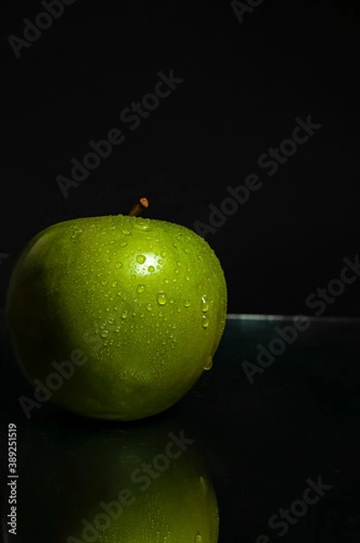 Obraz Close-up of fresh wet green apple on black background with reflection