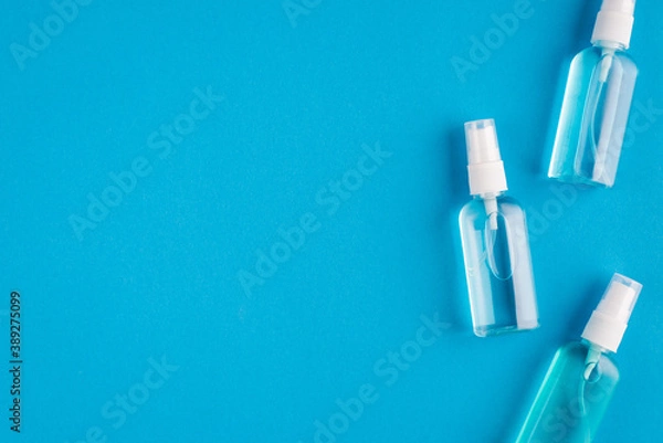 Fototapeta Top above overhead close up view photo of three little bottles with transparent sanitizing liquid isolated over bright color blue background