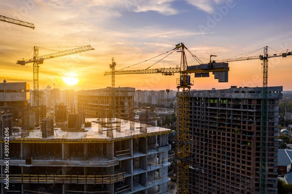 Obraz Construction site with cranes at sunset. Construction of an apartment building