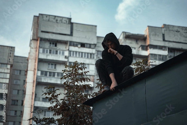 Obraz 
the man in black is sitting on the roof