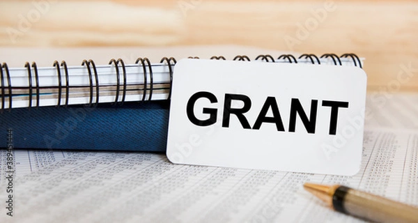 Obraz Text on the GRANT business card, next to textbooks, pen.