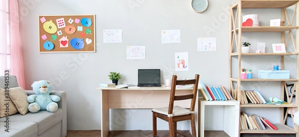 Fototapeta School child room interior space with table, couch, bookcase, books and laptop on table indoors at home apartment background. Children homeschool, online distance remote virtual learning, banner.