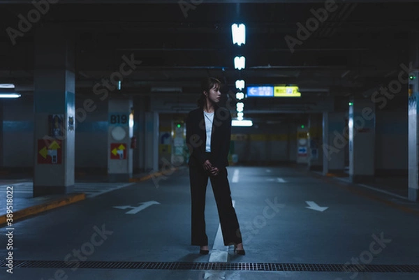 Fototapeta 夜の街にいるスーツの女性