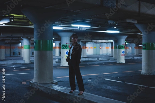 Fototapeta 夜の街にいるスーツの女性