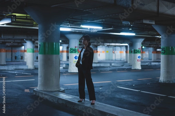 Fototapeta 夜の街にいるスーツの女性