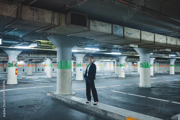 Fototapeta 夜の街にいるスーツの女性