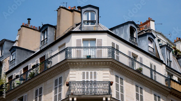 Obraz Typical front building in Paris, Blue sky and white clouds, roof and attic room, low-angle shot, haussmann facade, front buildings perspective, historic center, artistic view of the city, symmetry 