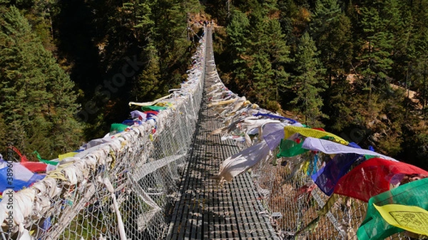 Obraz Colorful Buddhist prayer flags peacefully flying in the wind on popular Hillary Suspension Bridge on the way up to Namche Bazar, Himalayas, Nepal on Everest Base Camp Trek.