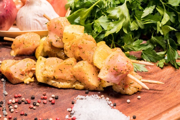 Fototapeta raw chicken skewers marinated with lemon on a wooden board