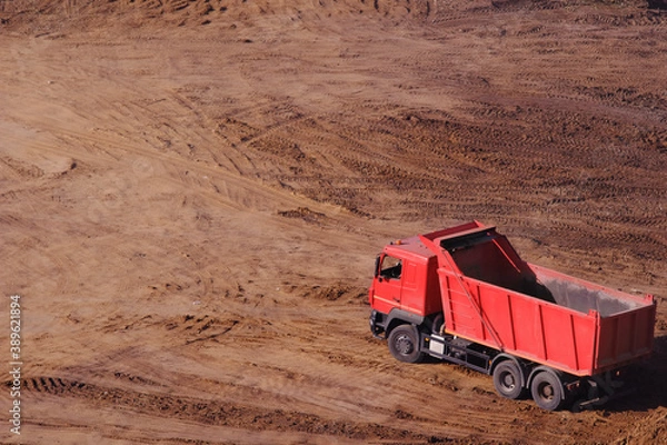 Fototapeta A red empty lorry stands on the sand View from above. Copy space for left and top text labeling