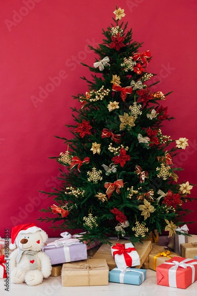 Fototapeta red decor garland Christmas tree with gifts for the new year interior