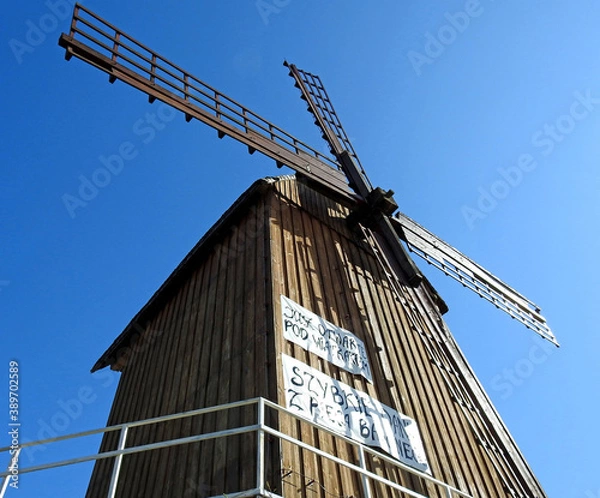 Fototapeta Grain mill Kozlak windmill standing by the Bug River in the village of Brok in Masovia, Poland on a white background an inscription advertising grandma's kitchen