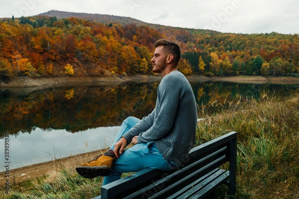 Obraz person sitting on a bench in the nature