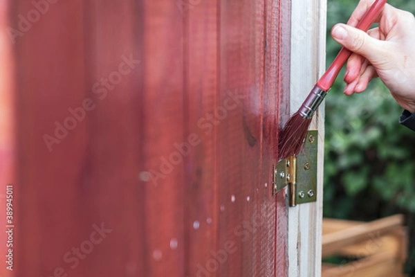 Obraz Holz mit einem Pinsel rot streichen