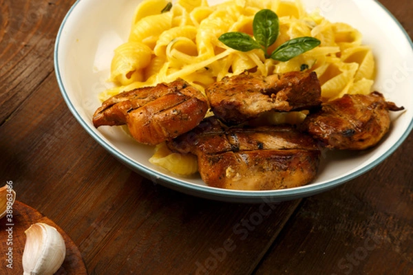 Fototapeta A plate of pasta in a creamy sauce with cheese and chicken.