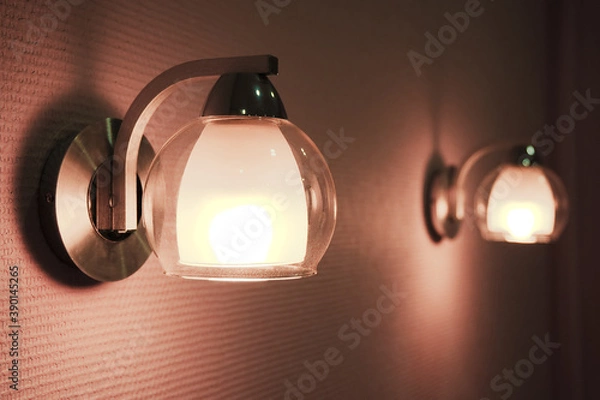 Fototapeta Pair of lamps lights in bedroom. The low key image of two night lamps.