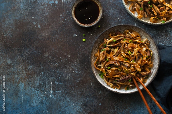 Obraz Brown rice noodles , beef, mushrooms and scallions plate on dark stone background