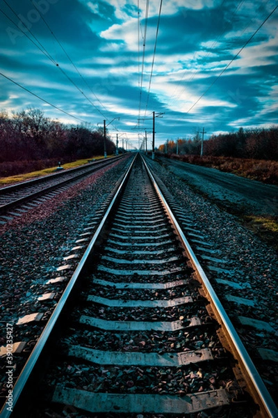 Fototapeta railway, rails and sleepers without trains close-up, on a beautiful sunset overcast sky