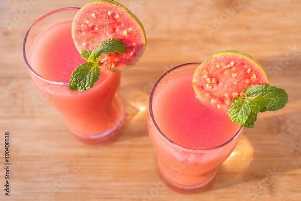 Obraz Directly above shot of glass of organic Guava juice with fresh guava on wooden table