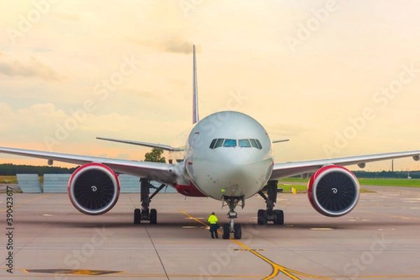 Fototapeta Front view of a wide body aircraft sunset at the airport.