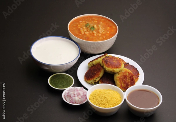 Fototapeta Ragda pattice -Aloo tikki or Potato Cutlet or Patties is a popular Indian street food made with boiled potatoes, spices and herbs served with tamrind chutney and peas curry.