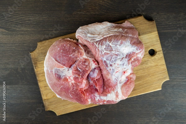 Fototapeta Juicy raw piece of meat on a wooden Board. The view from the top.