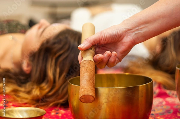 Fototapeta reiki session and sound harmonization with Tibetan bowls with hands giving relaxation to the woman in the zen space