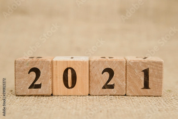 Fototapeta Happy New Year 2021 Christmas and New Year background. Symbol from number. Wooden cubes on canvas.