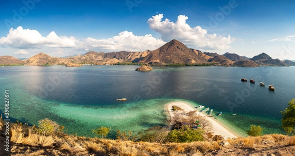Fototapeta Panormaric view of Komodo islands, Indonesia, from top of hill with mountains in background and crystal clear sea in foreground