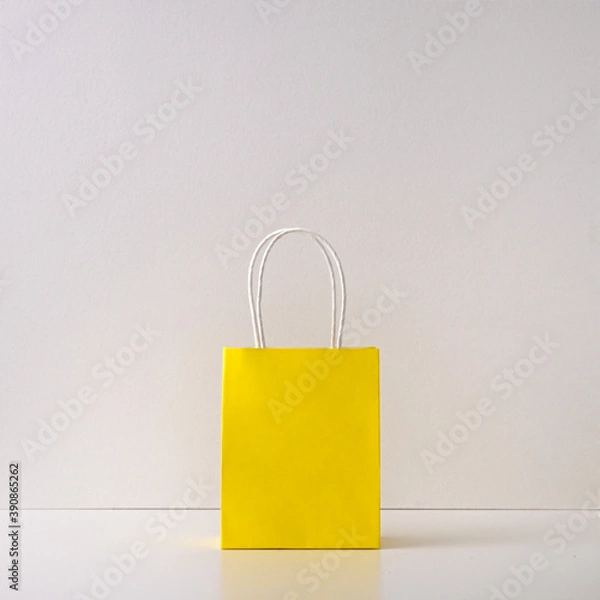 Fototapeta Gift yellow paper bag on a white background. Copy space, flat lay, mock up, top view