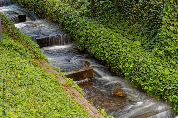 Obraz Close-up of flowing water in an artificial stream in a city park.