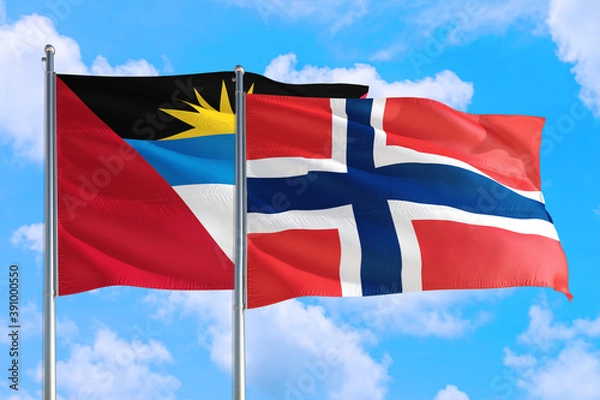 Fototapeta Norway and Antigua and Barbuda national flag waving in the windy deep blue sky. Diplomacy and international relations concept.