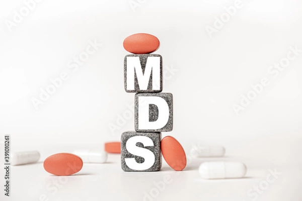 Fototapeta a group of white and red pills and cubes with the word MDS Myelo dysplastic syndrome on them, white background. Concept carehealth, treatment, therapy.