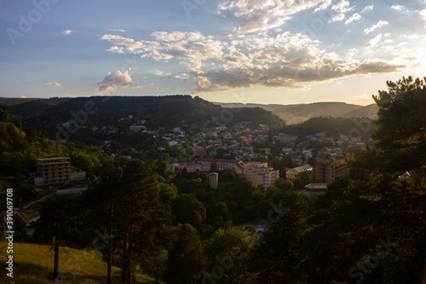 Fototapeta View from the mountain to the city park and houses with sunbeams