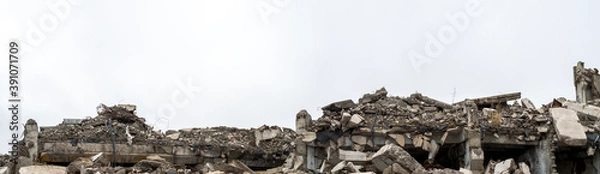 Fototapeta Panorama of the remains of a destroyed building, piles of concrete debris and construction debris. Background.