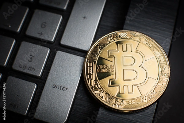 Obraz Złota moneta z symbolem kryptowaluty Bitcoin (BTC) na klawiaturze komputerowej: Naciśnij Enter, aby zaakceptować płatność elektroniczną